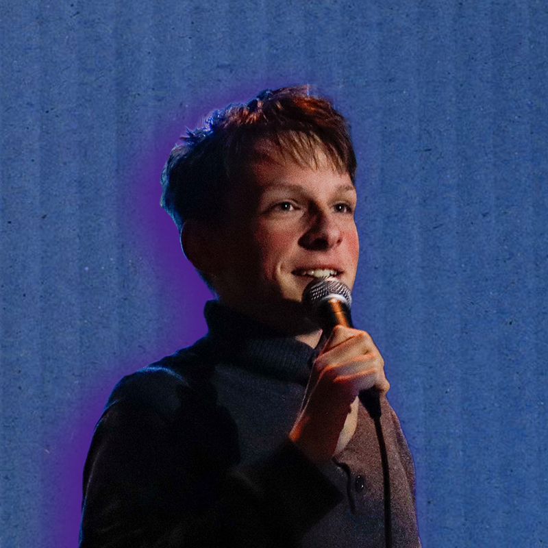 Portrait of Lucas Estrella holding a microphone under blue light
